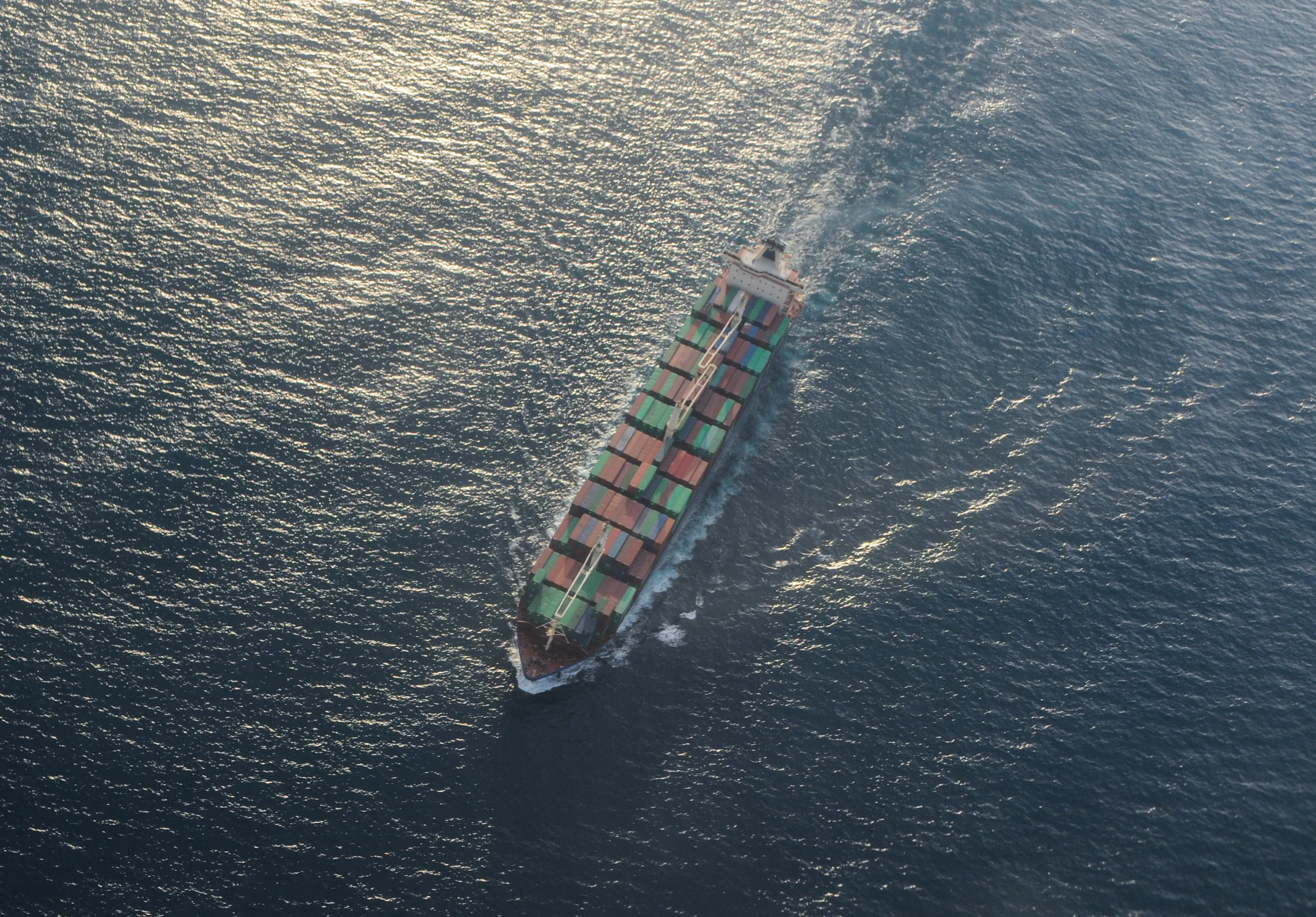 A container ship crossing open water, photographed from above