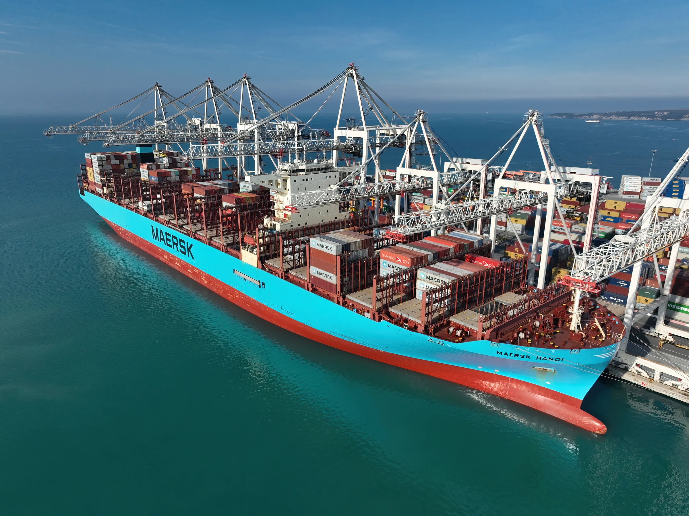 A cargo vessel alongside cranes at an international container port